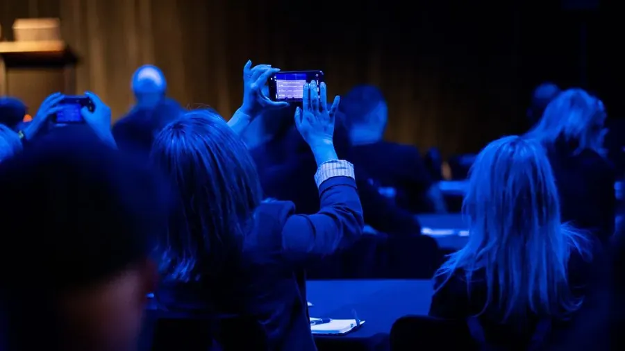 An audience member photographing the Roadshow stage on their phone